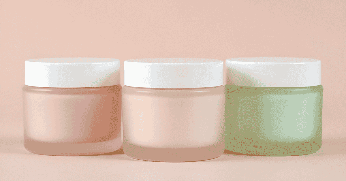 Trio of reusable cosmetic jars in pastel pink, white, and green against soft background