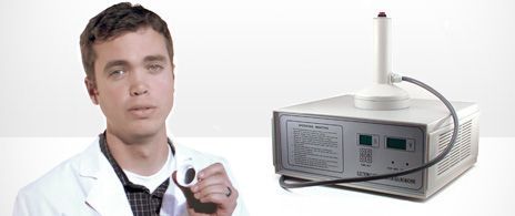 Heat induction sealing machine being used to apply an HIS liner to a container